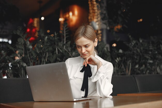 ノートパソコンでテーブルに座っている女性実業家