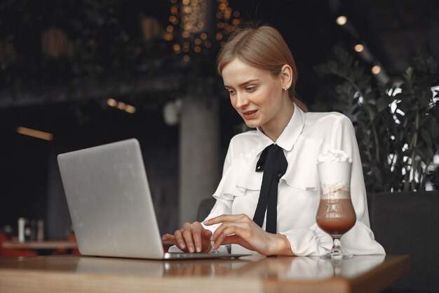 Businesswoman sitting at the table with a laptop