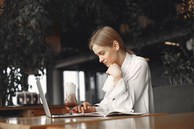 Businesswoman sitting at the table with a laptop
