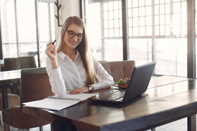 Businesswoman sitting at the table with a laptop