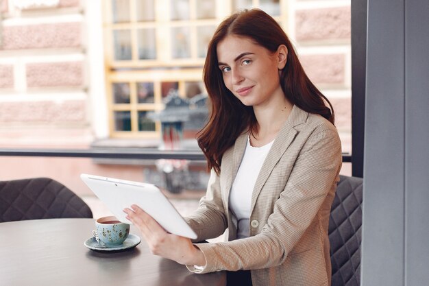 Businesswoman sitting at the table with a tablet