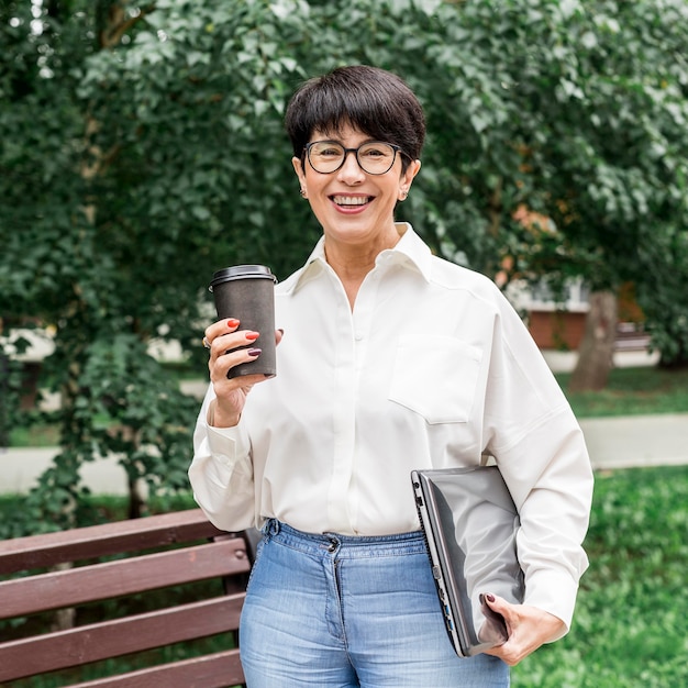 Free photo businesswoman smiling and enjoying her coffee