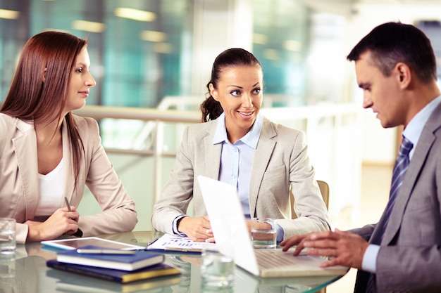 Free photo businesswoman smiling and her colleagues working