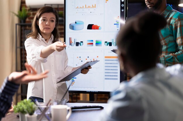 Businesswoman speaking with diverse group in office