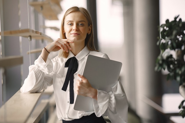 Businesswoman standing in the office with a laptop