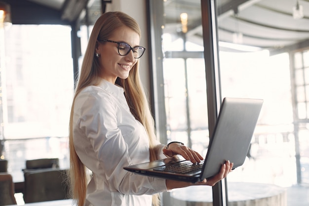 Businesswoman standing in the office with a laptop