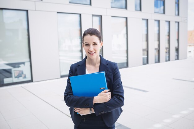 Free photo businesswoman standing outside office building