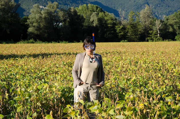 Imprenditrice in una tuta in piedi nel campo con una maschera subacquea