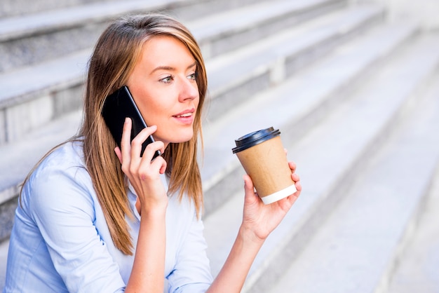 Free photo businesswoman taking a coffee break and using smartphone.