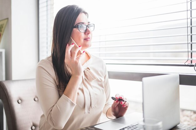 Businesswoman talking on cellphone in restaurant