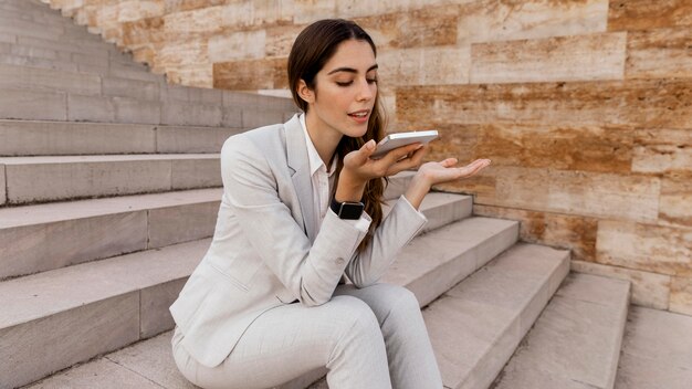 Businesswoman talking on the phone while sitting outdoors on stairs