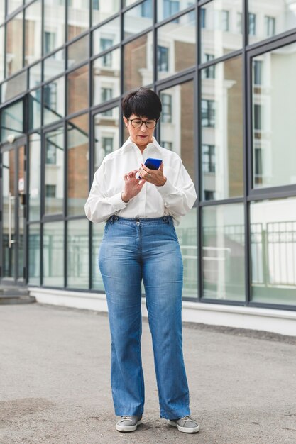 Businesswoman typing on her mobile phone long view