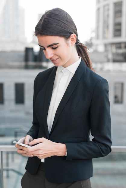 Businesswoman typing on smartphone