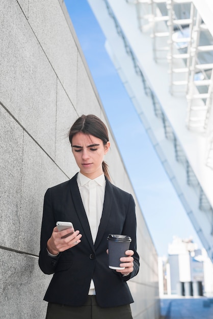 Free photo businesswoman typing on smartphone