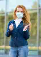 Free photo businesswoman using hand sanitizer and wearing medical mask