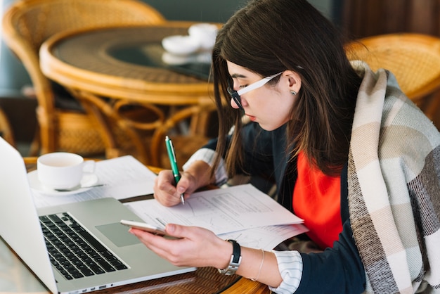 Businesswoman using laptop in coffee shop