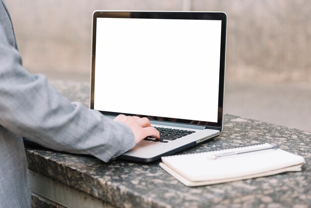 Businesswoman using laptop outdoors