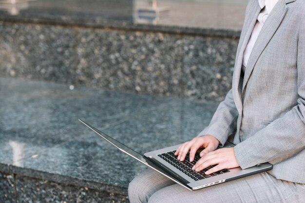 Businesswoman using laptop outdoors