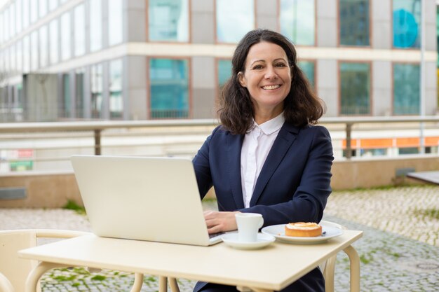 Businesswoman using laptop and smiling