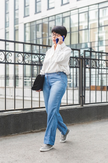 Free photo businesswoman walking next to a big building