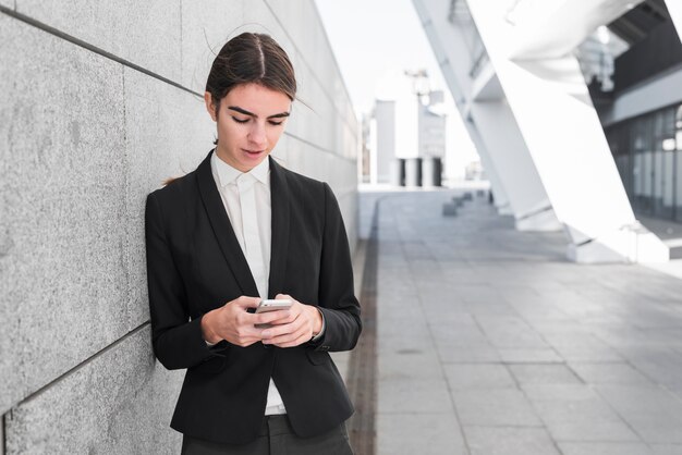 Free photo businesswoman next to wall