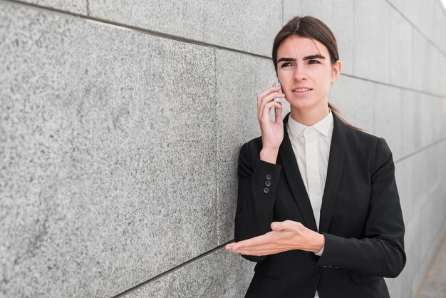 Businesswoman next to wall