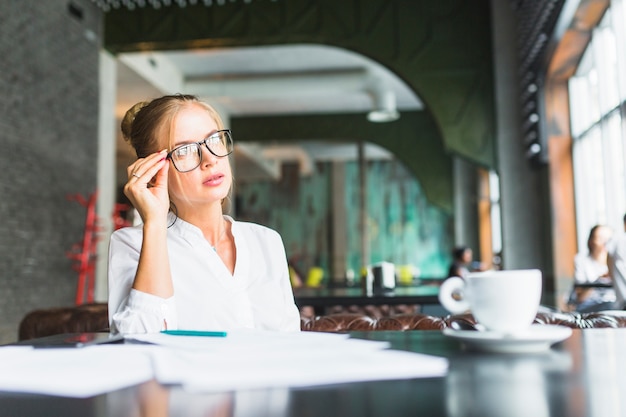 Businesswoman wearing spectacles sitting in restaurant