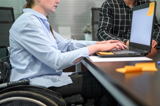 Free photo businesswoman in wheelchair ans post-it notes