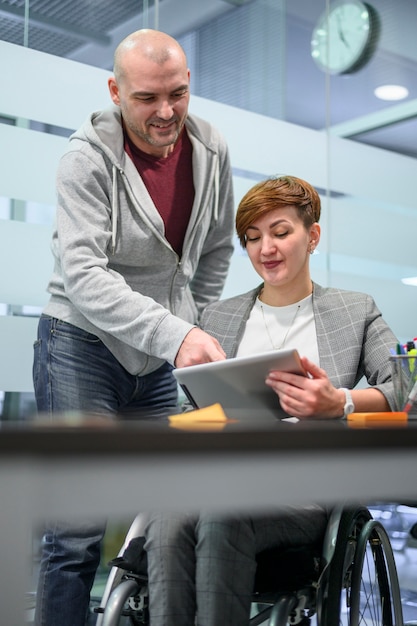 businesswoman in wheelchair talking to a coworker