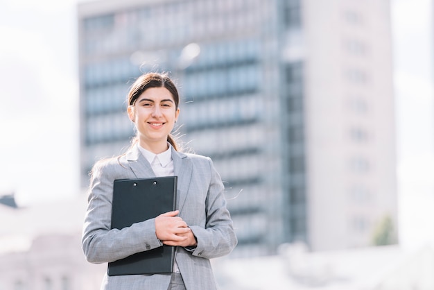 Businesswoman with clipboard outdoors