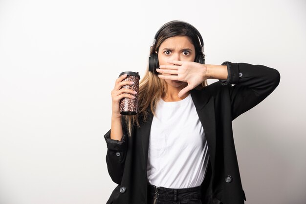Businesswoman with cup and headphones .