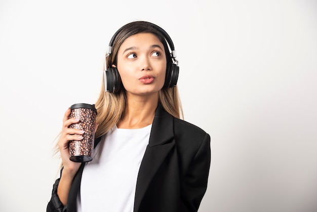 Businesswoman with cup and headphones . 