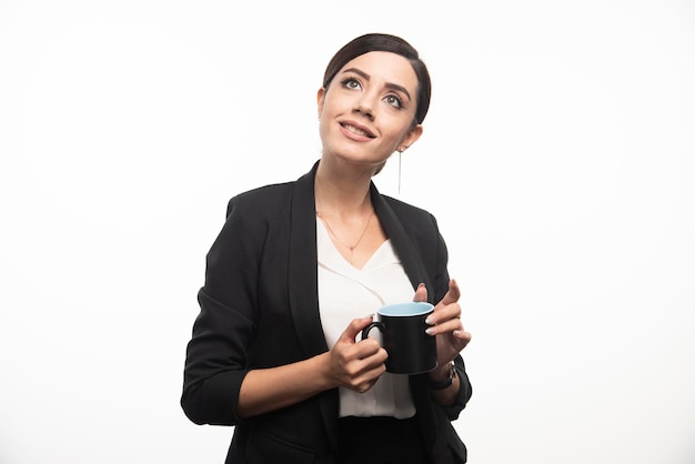 Businesswoman with cup and a pencil on a white background. High quality photo