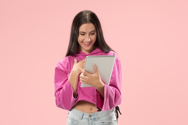 Businesswoman with laptop. Love to computer concept. Attractive female half-length front portrait, trendy pink  wall. Young emotional pretty woman. Human emotions, facial expression