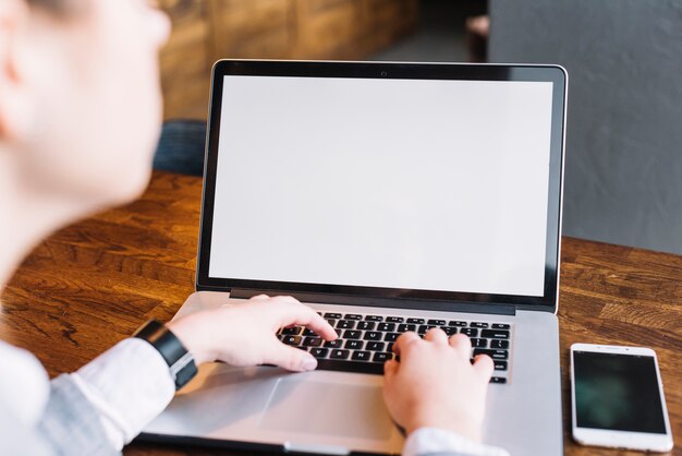 Businesswoman with laptop and smartphone in coffee shop