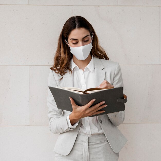 Businesswoman with mask and agenda