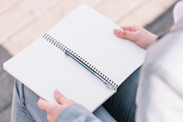 Businesswoman with open book outdoors