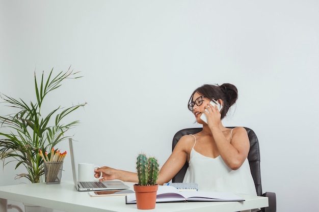 Free photo businesswoman with phone and coffee mug