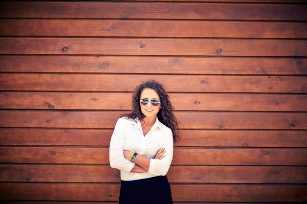 Businesswoman with sunglasses with wooden background