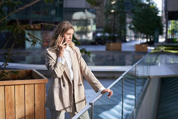 La donna d'affari con la faccia preoccupata e preoccupata parla sul telefono cellulare ha una conversazione difficile al telefono