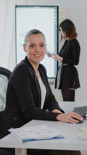 Businesswoman working on computer with data charts for management strategy in corporate office. Entrepreneur using technology and monitor for research analysis and design planning.