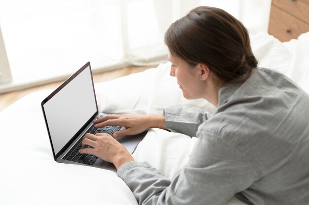 Businesswoman working from home in her bed