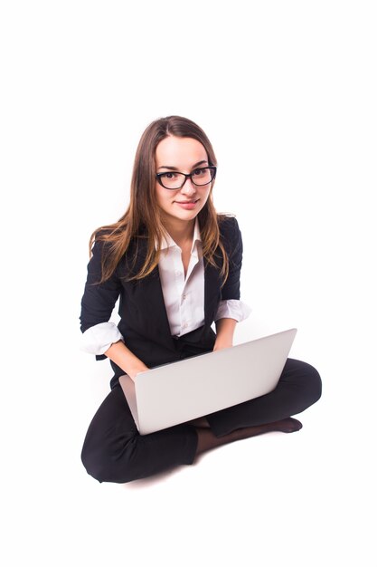 Businesswoman working on laptop isolated on white wall