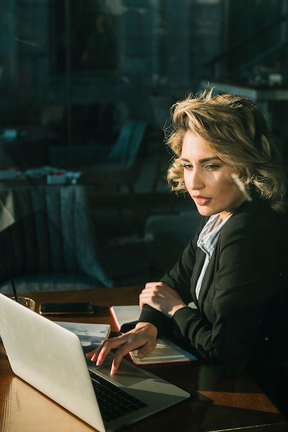 Businesswoman working on laptop over wooden desk