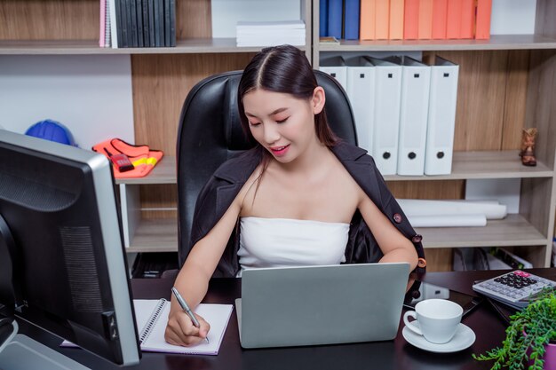 Businesswoman working in the office with a smile while sitting.