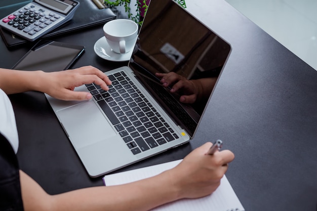 Businesswoman working in the office with a smile while sitting.