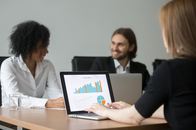 Businesswoman working with project statistics preparing report at team meeting