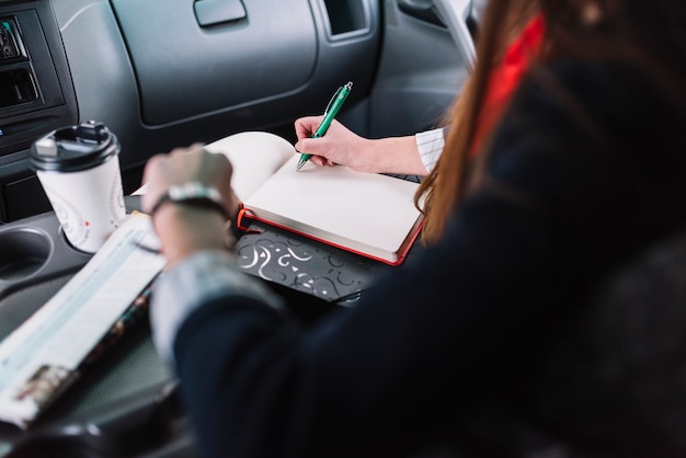 Businesswoman writing in car