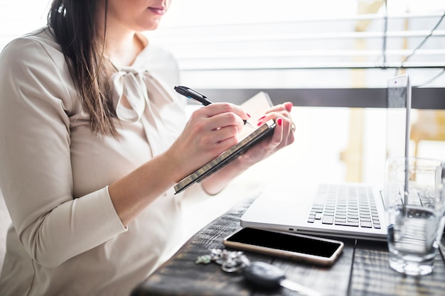 Free photo businesswoman writing on diary