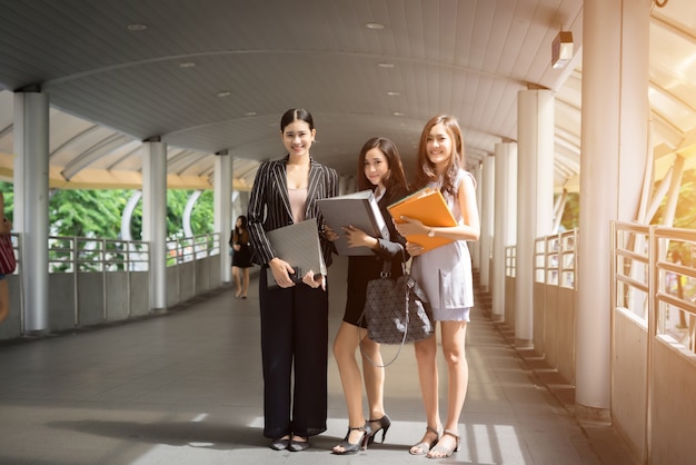 Businesswomen discussing over paperwork together against railing. Business people concept.